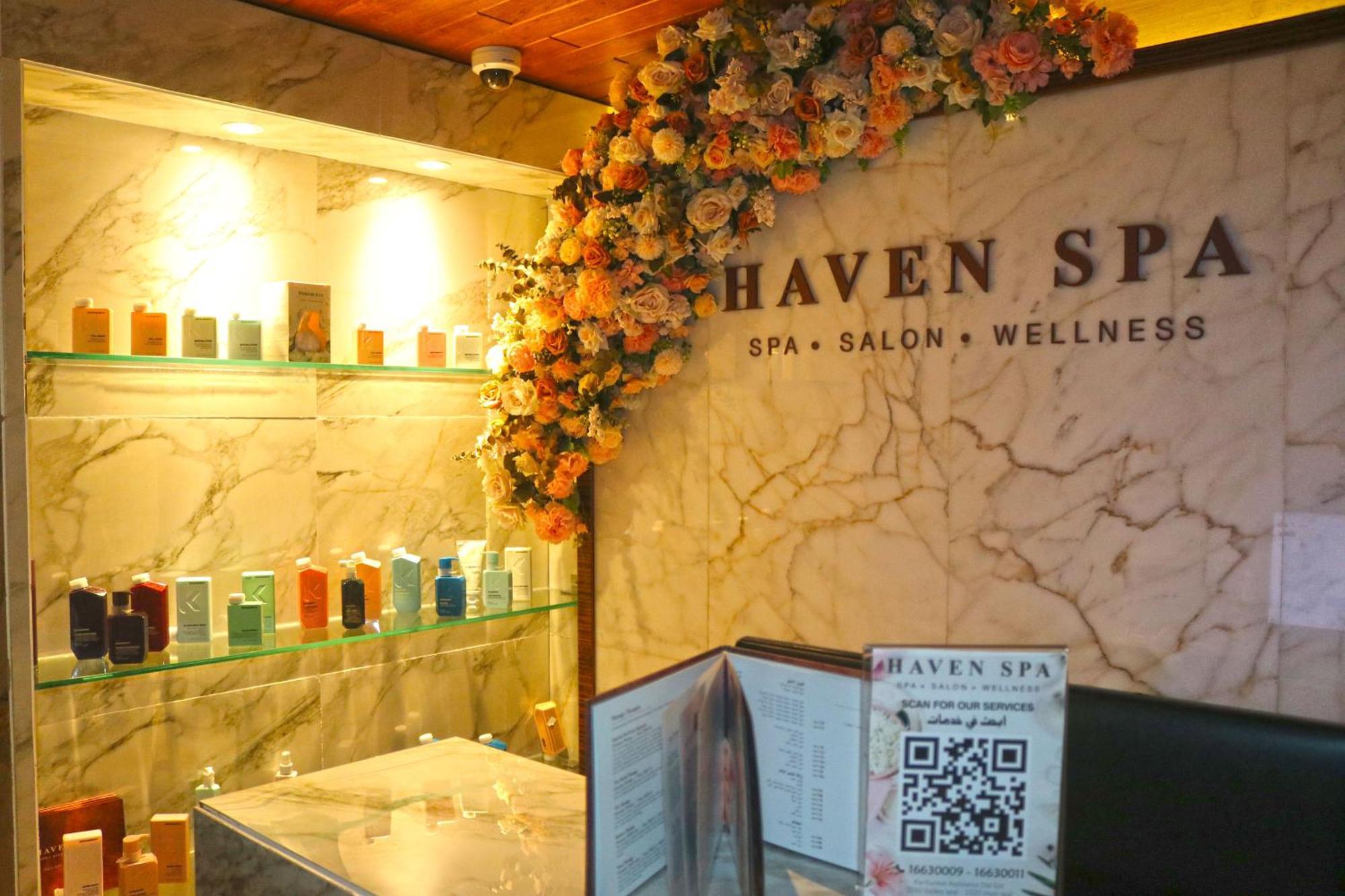 Lagoona Beach Luxury Resort And Spa Manama Exterior foto The photo shows the interior of a spa called "Haven Spa." The wall is decorated with beautiful artificial flowers, creating an inviting atmosphere. There are several shelves displaying various colorful bottles and products, likely for skincare or wel