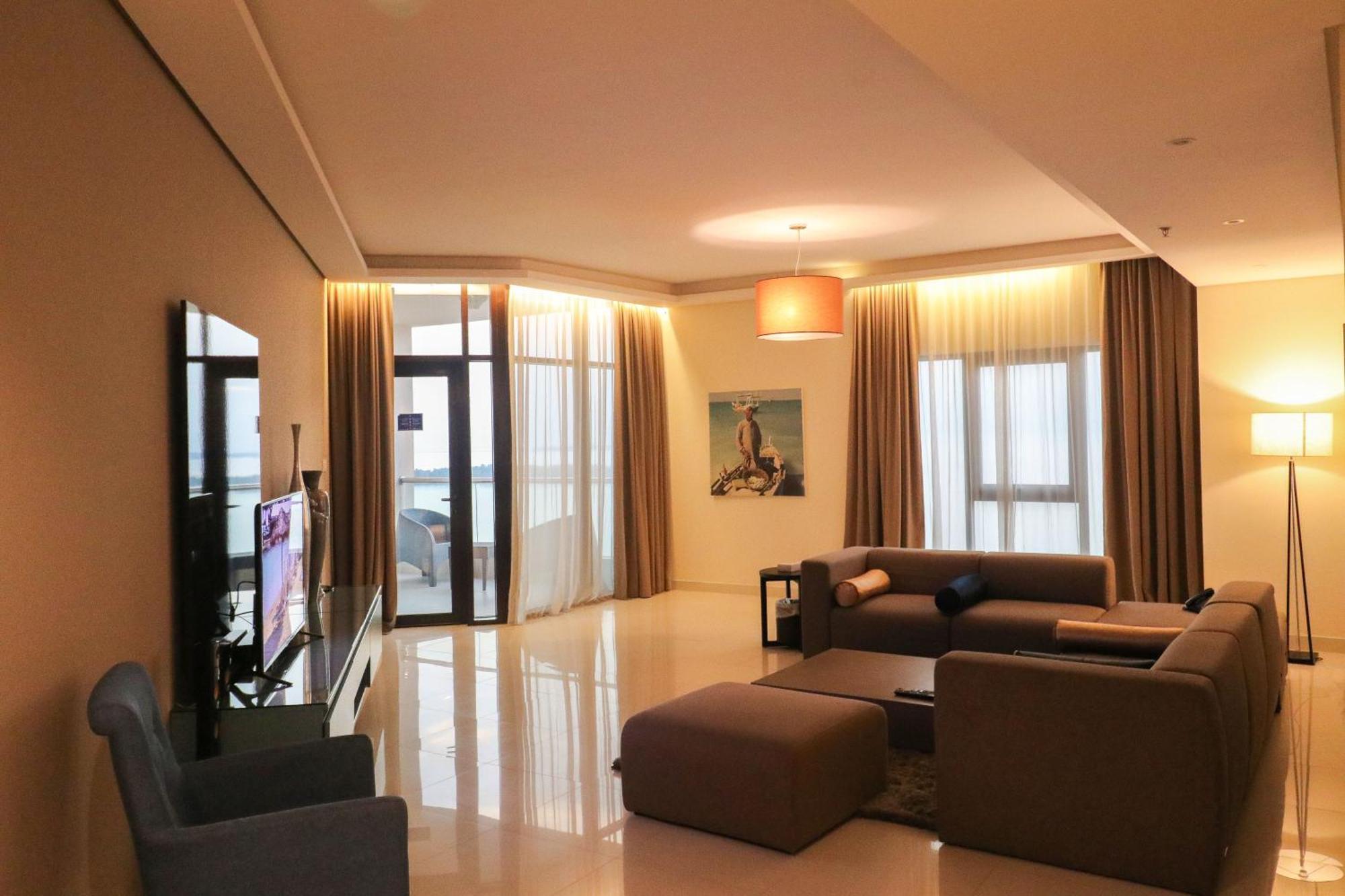 Lagoona Beach Luxury Resort And Spa Manama Exterior foto The photo shows a modern living room with a spacious and elegant design. It features a large couch in neutral tones, a soft ottoman, and a stylish coffee table. The walls are painted in a light color, and there are large windows with sheer curtains a